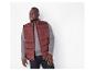 Homme en gilet matelassé bordeaux et t-shirt gris à manches longues.