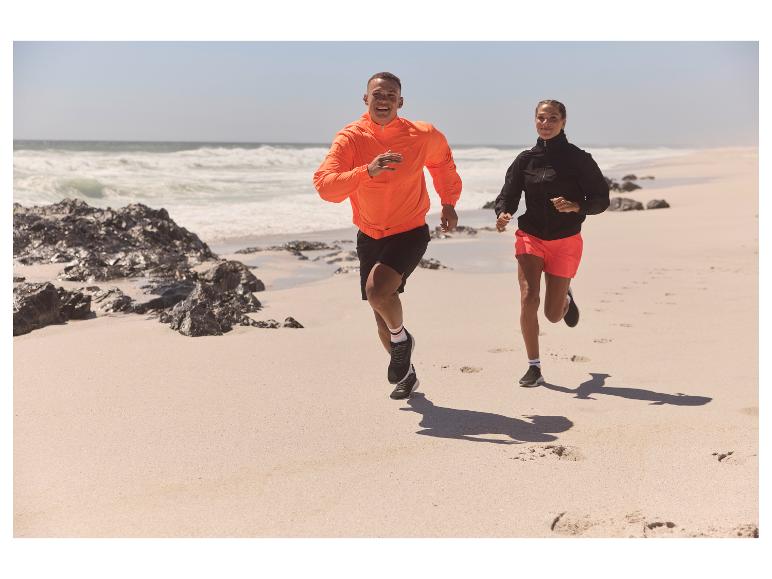 Couple courant sur la plage en vêtements de sport.
