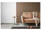 Décor de salon confortable avec un canapé beige, une table d'appoint et un mur en bois.