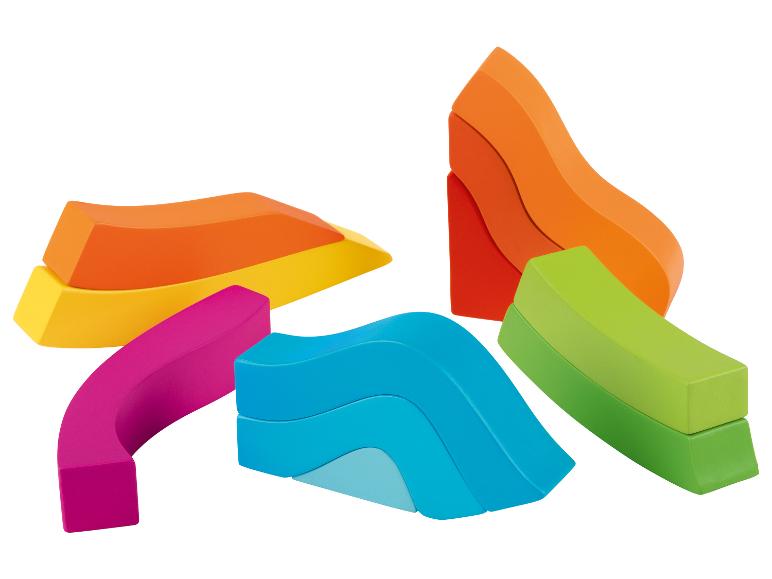 Blocs de bois colorés de formes différentes, dont un toboggan bleu et un pont vert.