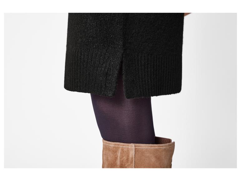 Jupe noire tricotée avec fente latérale, collants violets et bottes en daim marron.