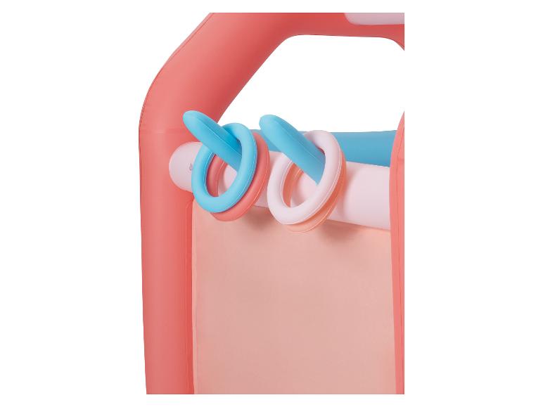 Gros plan d'un tapis d'éveil coloré avec des anneaux suspendus roses, bleus et blancs.