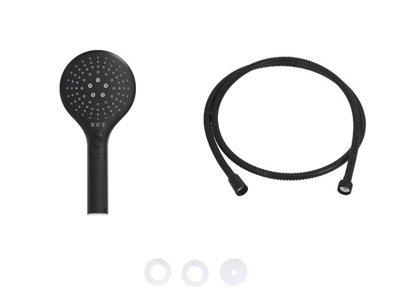 Pommeau de douche noir avec flexible et trois rondelles blanches sur fond blanc.