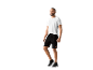 Homme portant un t-shirt blanc et un short noir.