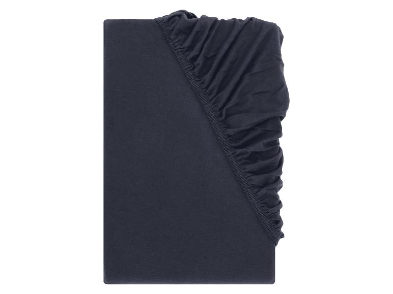 Drap-housse bleu foncé, plié avec des détails élastiques visibles.