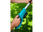 Un homme utilise une taille-haie sans fil bleue dans le jardin.