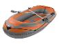 Bateau gonflable orange et gris avec rames, avec une corde autour du périmètre.