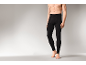 Un homme portant un legging thermique noir, debout sur fond gris.