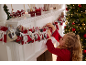 Fille arrangeant un calendrier de l'Avent sur la cheminée, avec des décorations de Noël.