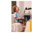 Enfant sur un fauteuil en velours côtelé lisant un livre.