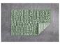 Un tapis de bain vert texturé sur un carrelage gris.