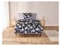 Un lit avec une couette bleu foncé à motif floral.