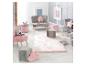 Salle de jeux pour enfants avec mobilier rose et gris, coussins étoile et lapin.