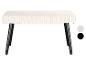 Un banc blanc avec des pieds noirs.