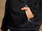 Gros plan sur une veste softshell noire avec une poche à fermeture éclair.