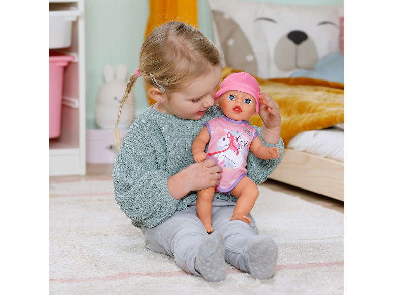 Petite fille jouant avec une poupée dans une chambre d'enfant.