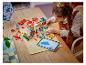 Fille construisant une maison Lego avec des instructions numériques sur une tablette.