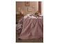 Une chambre douillette avec une housse de couette fleurie et un couvre-lit rose matelassé.