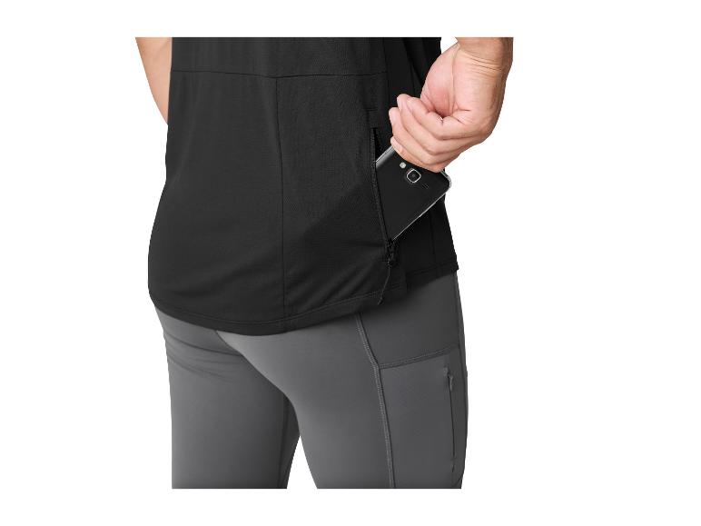 Homme en t-shirt noir et pantalon gris, mettant un téléphone dans une poche latérale zippée.