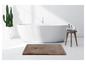 Un tapis de bain marron dans une salle de bain avec une baignoire.