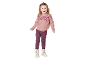 Fillette en pull rose à motifs, legging bordeaux et bottes blanches.