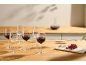 Verres à vin, carafe, fromage et raisins sur une table en bois.
