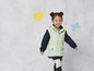 Une fille porte une veste verte à capuche et un pantalon noir.