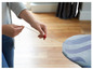 Une femme tend une housse de planche à repasser avec un motif ondulé.
