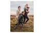Famille en doudounes et chaussures robustes marchant dans un paysage herbeux.