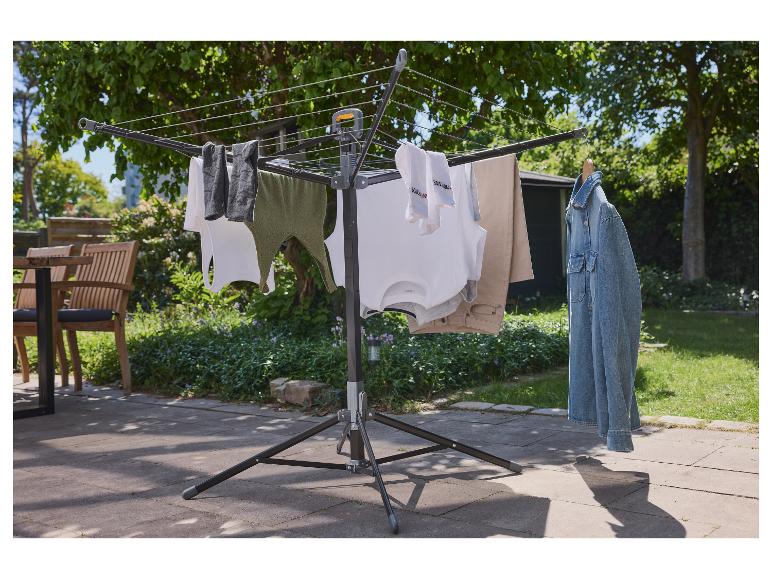Un étendoir à linge pliable d'extérieur avec des vêtements suspendus.