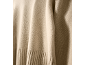 Gros plan d'un pull en maille beige doux avec ourlet côtelé