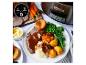 Une mijoteuse Crock-Pot avec une assiette de bœuf rôti, de pommes de terre, de légumes et de pudding Yorkshire.