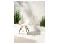 Chaise design, lampadaire et plantes vertes créant une ambiance zen.