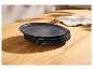 Assiettes noires empilées sur une table en bois avec un torchon.