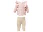 Ensemble bébé avec un haut rose à manches longues et volants et un legging côtelé beige.