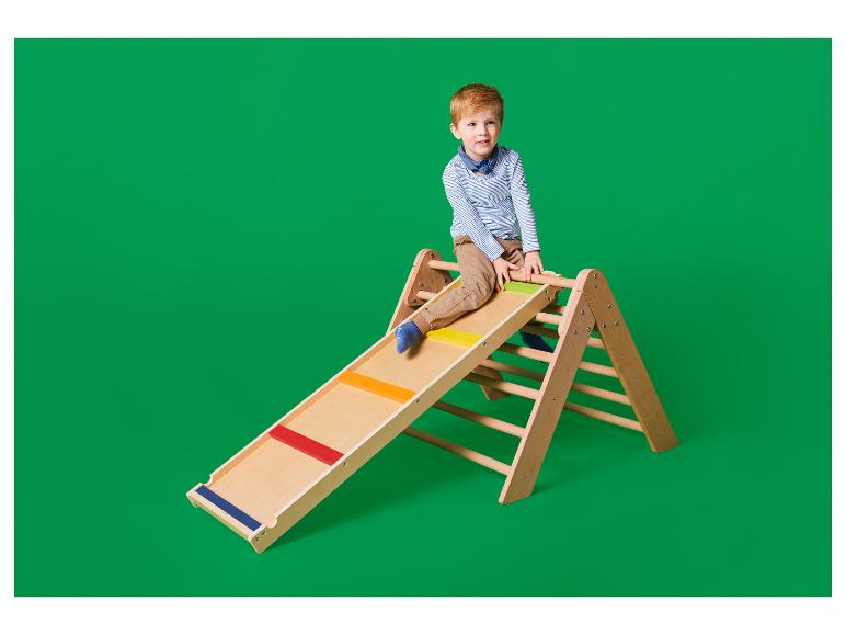 Garçon sur une structure d'escalade en bois avec toboggan