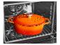 Marmite en fonte orange avec couvercle à l'intérieur d'un four