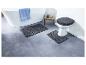 Deux tapis de bain gris et un abattant de WC avec un doux revêtement gris.