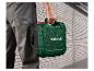 Une personne porte une boîte à outils verte Parkside.