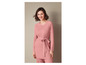 Un pull et un pantalon rose en tricot avec une ceinture.