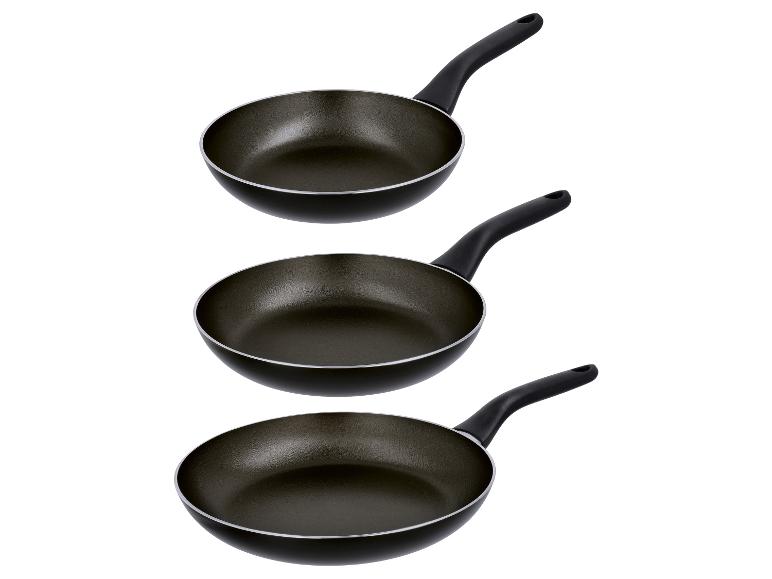 Trois poêles à frire noires de tailles différentes avec des manches noires.