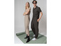 Une femme porte une robe beige et des bottes noires, un homme porte un polo vert et un pantalon avec des Vans blanches.