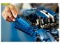 Une personne assemble un modèle bleu LEGO Technic Ford GT.