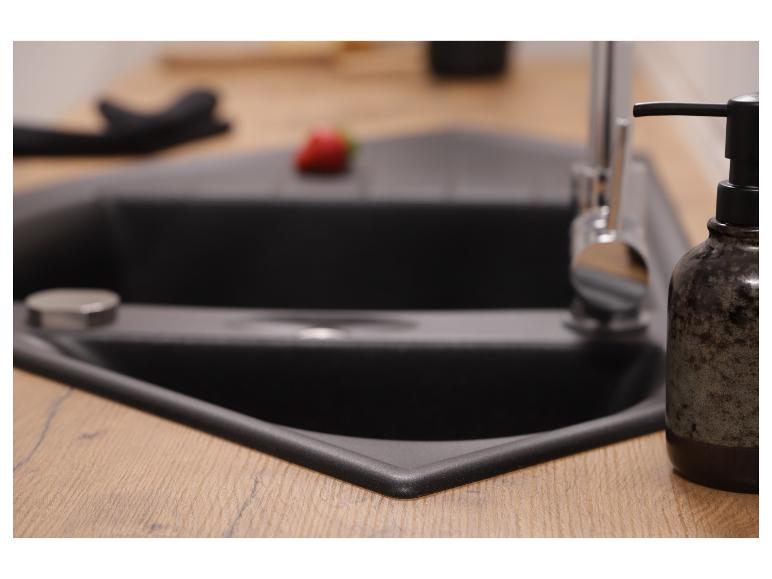 Évier de cuisine d'angle noir avec plan de travail en bois et distributeur de savon.