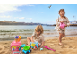 Deux enfants jouent avec des jouets de sable, dont un seau à glace et un arrosoir, sur la plage.