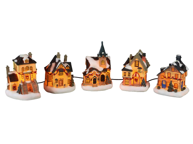 Maisons de Noël illuminées avec de la neige sur les toits, style village d'hiver.