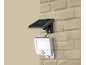 Projecteur de sécurité LED solaire avec détecteur de mouvement sur mur de briques.