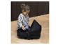 Un enfant joue avec une nacelle de poussette noire.