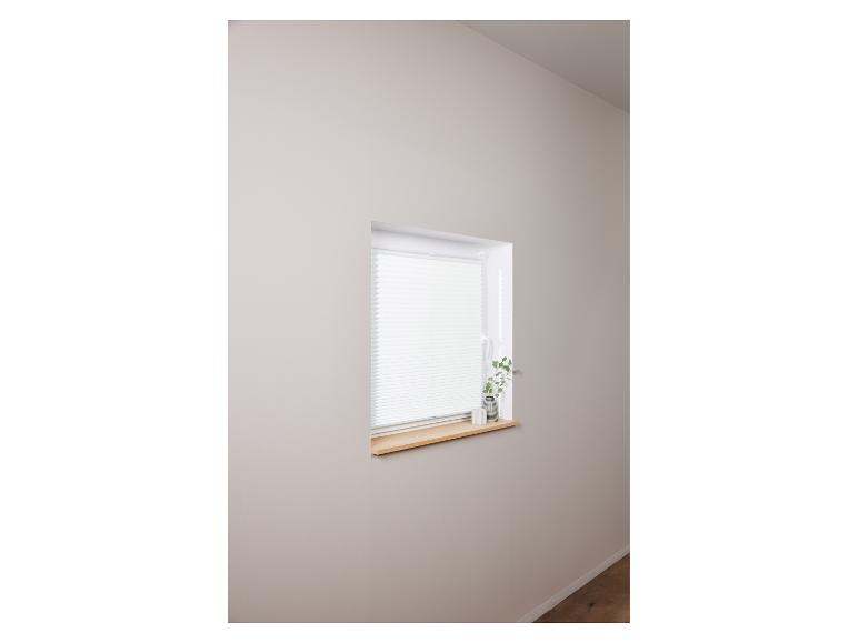 Décoration de fenêtre minimaliste avec des stores blancs et un petit rebord de fenêtre en bois.