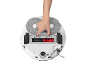 Une main retirant le couvercle de la brosse principale sous un robot aspirateur.